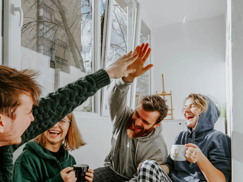 Friends high-fiving over coffee